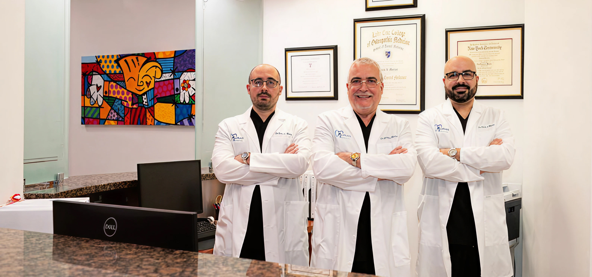 Drs. German, Eric, and Frank Murias standing in Murias Dental clinic, Hialeah & Plantation, FL