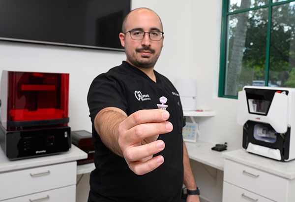 Close-up of dentist showing custom dental crown made in Murias Dental lab