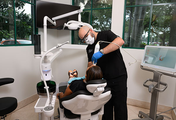 Dentist performing treatment using advanced dental equipment in Murias Dental in-house lab